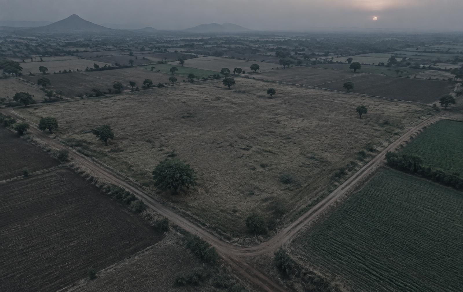 Illustrative aerial view of an undeveloped land parcel bounded by dirt tracks